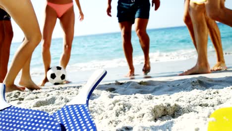 Niedrige-Abschnitt-von-Freunden-Fußball-spielen-am-Strand