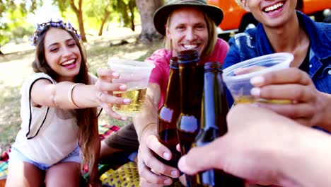 Friends-toasting-beer-bottles-in-the-park-4k
