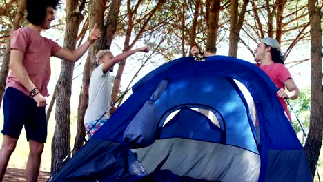 Friends-giving-high-five-while-preparing-tent-in-park-4k