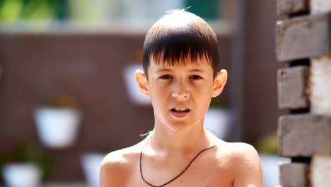 wet-serious-boy-after-a-swimming-pool-looks-at-the-camera,-close-up