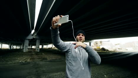 Athlet-Mann-mit-video-Chat-auf-Smartphone-mit-seinem-Trainer-nach-dem-Training-am-städtischen-Standort-im-Freien-im-winter