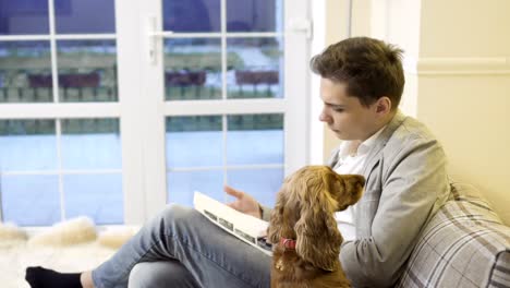 Gut-aussehender-Mann-mit-Hund-sitzt-auf-dem-sofa