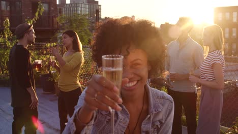 Joven-mujer-negra-de-elevar-un-vaso-a-la-cámara-en-la-fiesta-en-la-azotea