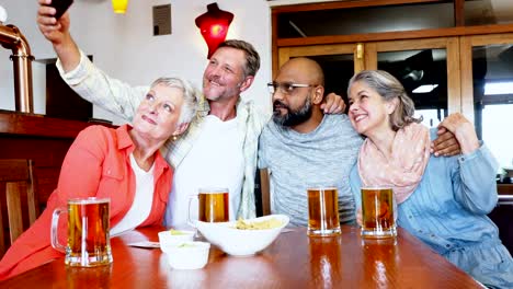 Friends-taking-selfie-with-mobile-phone-in-bar-4k