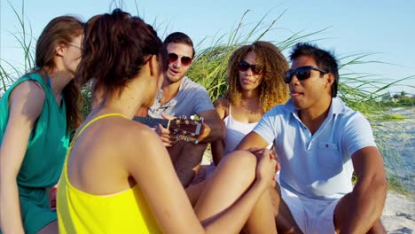 Multi-ethnischen-Freunde-mit-Picknick-am-Strand-entspannen