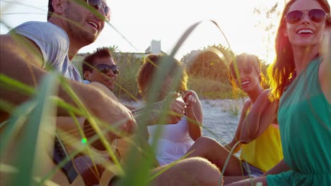 Young-multi-ethnic-friends-enjoying-picnic-on-beach