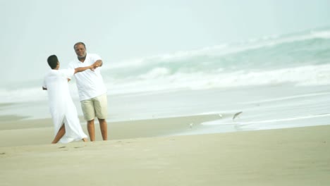 Ehemaliger-senior-ethnischen-Paare-tanzen-zusammen-am-Strand