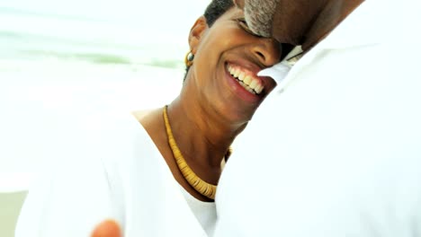 Retired-ethnic-couple-dancing-on-beach-enjoying-togetherness