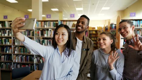 Gruppe-von-internationalen-Studenten-Spaß-haben,-lächelnd-und-Selfie-Fotos-auf-Smartphone-Kamera-an-der-Universitätsbibliothek.-Fröhliche-Freunde-haben-Pause,-während-Preapre-Projekt-zusammen