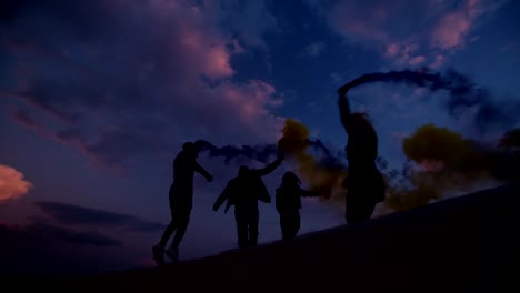 Gruppe-junger-Freunde-feiern-mit-Rauchbomben-nach-Sonnenuntergang