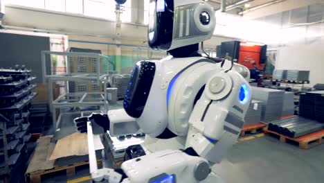 Ein-weiße-Roboter-trägt-ein-Metall-Element-in-einer-Fabrik,-Nahaufnahme.