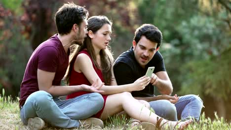 taking-selfie-at-the-park--three-young-friends-sitting-on-the-lawn-making-selfie