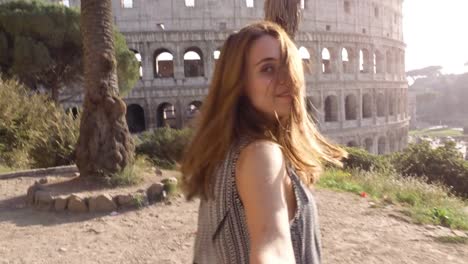 Schöne-junge-Frau-mit-langen-Haaren-führen-Freund-bei-der-Hand-in-Richtung-Kolosseum-in-Rom-bei-Sonnenuntergang-kommen-bei-mir-attraktive-glückliches-Paar