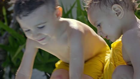 Kleine-Jungs-spielen-mit-Wasser-im-Schwimmbad