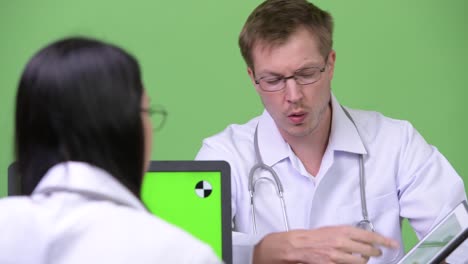 Young-Asian-woman-doctor-having-meeting-with-young-man-doctor