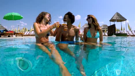 Happy-group-of-friends-drinking-at-the-swimming-pool