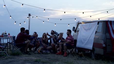 Friends-having-rest-in-campsite-having-drinks