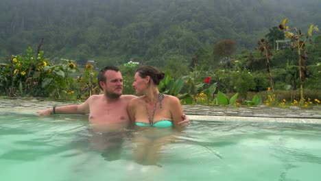 Un-hombre-abrace-a-una-mujer-en-una-piscina-con-agua-termal