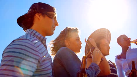 Gruppe-von-Freunden-Toasten-Bierflaschen-am-Strand-4k