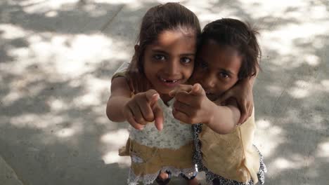 Sisters-bonding-together-playing-jumping-and-point-at-the-sky-to-camera