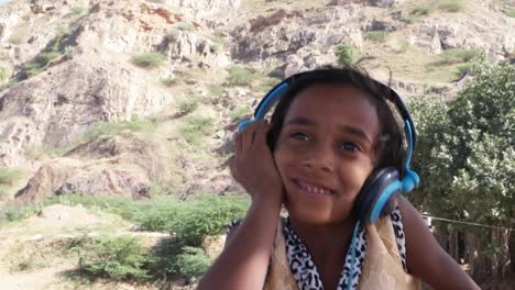 Schöne-kleine-indische-Musik-auf-große-Kopfhörer-hören-und-springen-und-tanzen-vor-Freude
