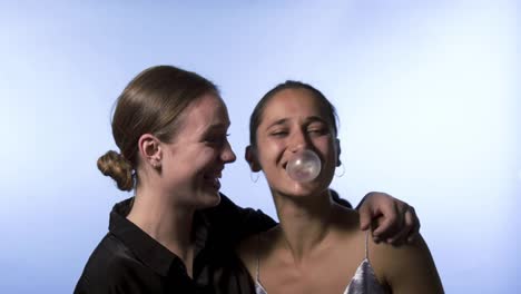 Zwei-junge-Frauen-weht-Bubble-Gum-und-lachen