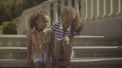 Smiling-little-sisters-bonding-and-embracing-outdoors