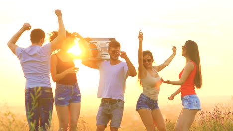 La-gente-feliz-con-una-caja-de-auge-bailando-sobre-un-fondo-de-amanecer.-cámara-lenta