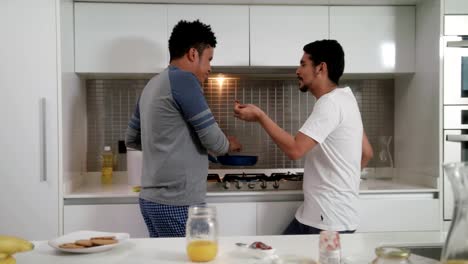 Homosexual-Couple-Eating-Breakfast-Cooking-In-Kitchen