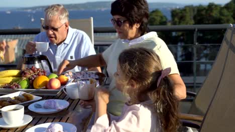 Eine-große,-glückliche-Familie-hat-Abendessen-auf-der-Terrasse-auf-dem-Dach-des-Hauses.