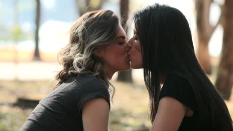 Lesbisches-Paar-küssen-jede.-LGBT-Freundin-küsst-weiblichen-Kumpel-im-park
