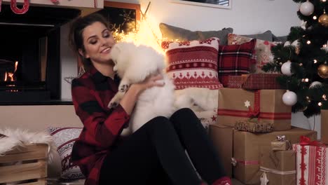 Woman-cuddling-her-cute-small-dog-at-christmas