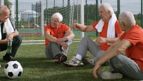 Relajante-en-el-césped-después-de-juego-de-fútbol-seniors