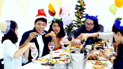 Group-of-asian-people-having-dinner-at-new-year-party-together.-People-Sitting-Around-a-Table-and-eating-food-together.-People-with-new-year-party-concept.