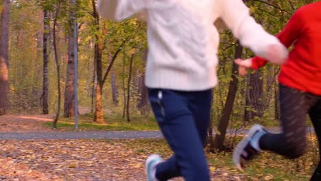 Happy-adorable-girls-running-with-leaf-bouquets-in-autumn-park-in-slow-motion