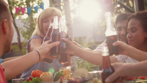 Familie-und-Freunde-versammelten-sich-am-Tisch-Raise-Gläser-und-Flaschen-um-einen-Toast-und-Clink-Gläser.-Große-Familie-Garten-Party-feiern.-Erhöhte-Kameraeinstellung.