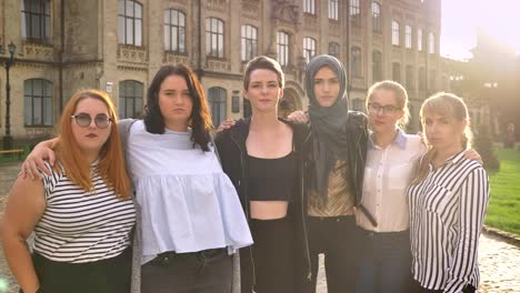 verschiedene-kaukasische-Frauen-stehen-Ing-und-umarmen-mit-schweren-konzentrierte-Gesichter-auf-der-Straße