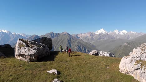 Aerial-shot-of-a-group-of-tourists-with-backpacks-climb-the-mountain.