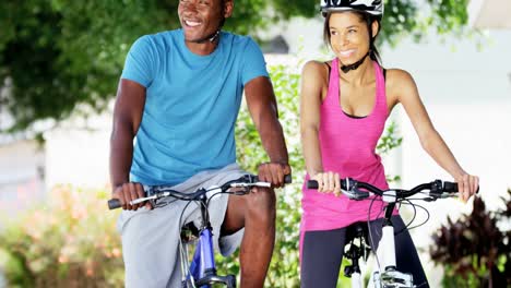 Portrait-ethnic-couple-cycling-to-keep-fit-outdoors