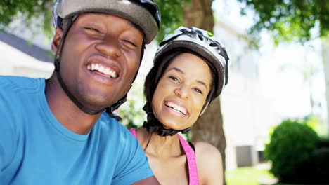 Portrait-young-ethnic-couple-enjoying-bike-ride-outdoors