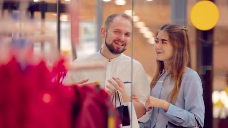 Mann-und-Frau-stehen-hinter-einem-Schaufenster-und-diskutieren-über-etwas