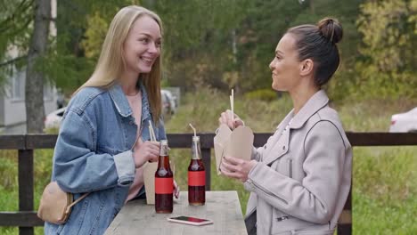 Dos-chicas-comiendo-comida-rápida-fuera-de