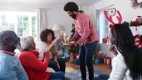 Porträt-von-Eltern-mit-Erwachsenen-Nachkommen-einen-Toast-mit-Champagner-zu-machen,-wie-sie-Weihnachten-feiern