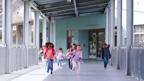 Elementary-school-kids-run-to-camera-in-school-corridor