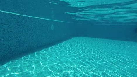 Divertido-niño-bajo-el-agua-en-la-piscina