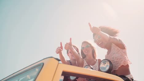 Afro-Mädchen-und-Freunde-Daumen-hoch-auf-road-trip