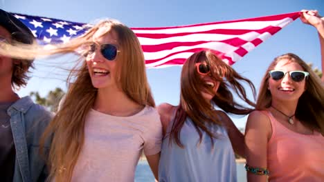 Cool-teen-friends-smiling-and-holding-an-American-flag