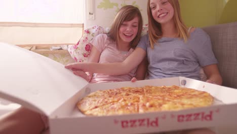 Grupo-de-adolescentes-felices-que-se-abren,-una-caja-de-Pizza-en-el-dormitorio