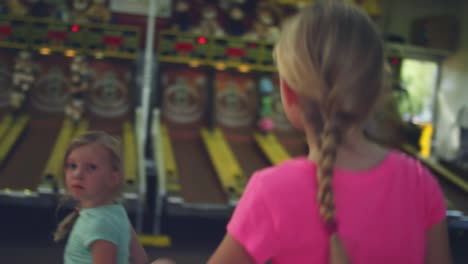 Zwei-kleine-Mädchen-zu-Fuß-bis-zum-Spielen-skee-ball