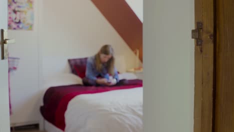 Young-girl-on-bed-messaging-on-smartphone-(Blurred)